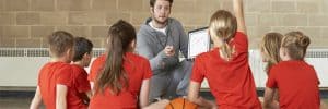 Coach-Giving-Team-Talk-To-Children-Basketball