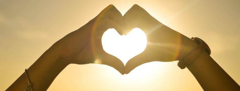 Two-People-Forming-Heart-Sign-to-Sun