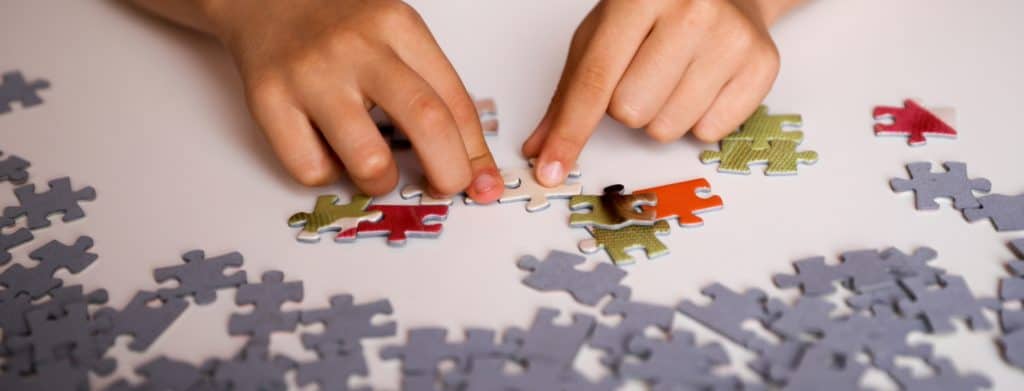 person-trying-to-solve-jigsaw-puzzle