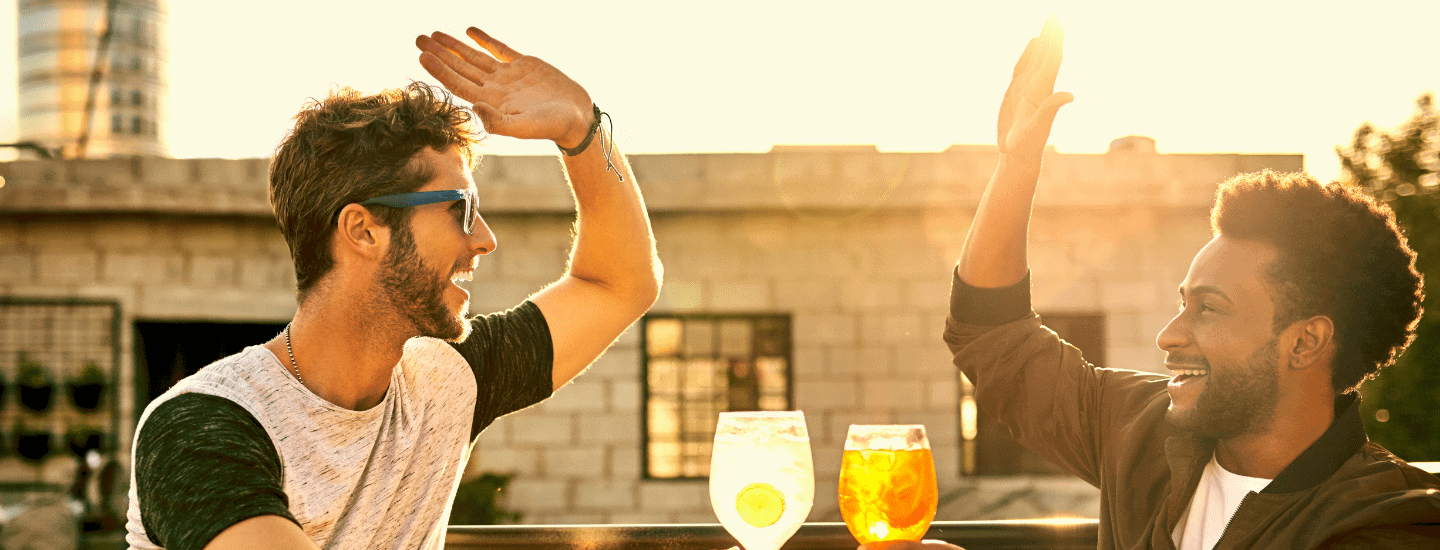 two friends high fiving at a bar